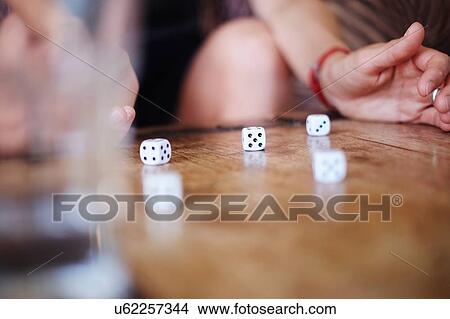Cropped shot of mature woman playing with dice on table View Large Photo Image Picture - Cropped shot of mature woman playing with dice on table. Fotosearch