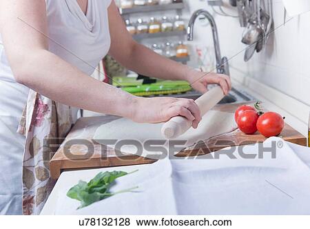 Cropped shot of woman rolling out pastry on kitchen counter View Large Photo Image Stock Photo - Cropped shot of woman rolling out pastry on kitchen counter. Fotosearch