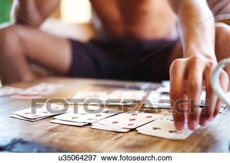 Cropped shot of young man playing cards at table View Large Photo Image Stock Photo - Cropped shot of young man playing cards at table. Fotosearch