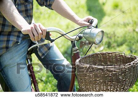Cropped view of young man cycling on grass View Large Photo Image Stock Image - Cropped view of young man cycling on grass. Fotosearch