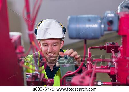 Stock Photography - Engineer doing maintenance in geothermal power station. Fotosearch