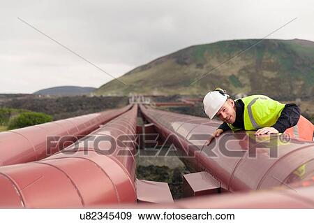 "Engineer inspecting pipes at geothermal power station, Reykjanes, Iceland" View Large Photo Image Stock Photo - "Engineer inspecting pipes at geothermal power station, Reykjanes, Iceland". Fotosearch