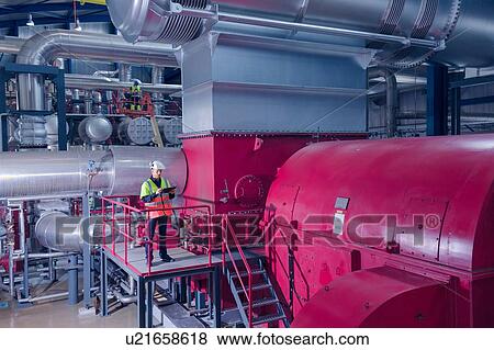 Stock Photo - Engineer on access platform using digital tablet at geothermal power station. Fotosearch