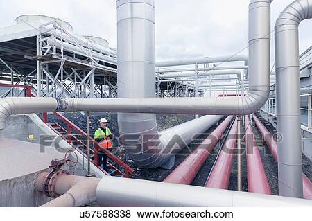 Stock Photo - Engineer on stairway at geothermal power station. Fotosearch