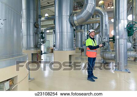 Engineer using digital tablet in geothermal power station View Large Photo Image Picture - Engineer using digital tablet in geothermal power station. Fotosearch