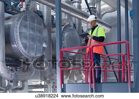 Picture - Engineer using digital tablet on access platform in geothermal power station. Fotosearch