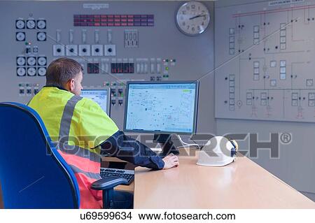 Picture - Engineer working on computer in control room at geothermal power station. Fotosearch