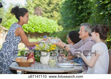 "Family enjoying meal, outdoors" View Large Photo Image Stock Image - "Family enjoying meal, outdoors". Fotosearch