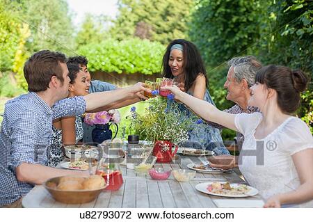 Stock Image - "Family enjoying meal, outdoors". Fotosearch