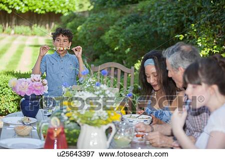 Stock Photo - "Family enjoying meal, outdoors". Fotosearch