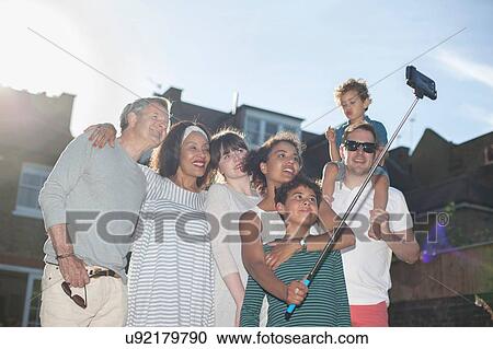 "Family in the garden taking a self portrait, using a selfie stick" View Large Photo Image Stock Image - "Family in the garden taking a self portrait, using a selfie stick". Fotosearch