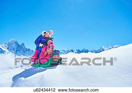 Stock Image - "Family playing in snow, Chamonix, France". Fotosearch