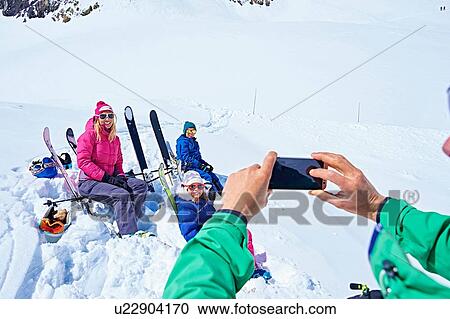 Stock Image - "Family taking photograph on ski trip, Chamonix, France". Fotosearch
