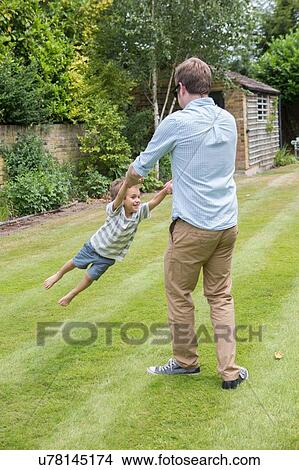 Father and son playing together in garden View Large Photo Image Picture - Father and son playing together in garden. Fotosearch