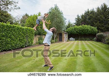 Father and son playing together in garden View Large Photo Image Stock Photo - Father and son playing together in garden. Fotosearch