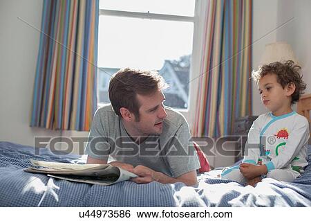 Father and son relaxing on bed View Large Photo Image Stock Photograph - Father and son relaxing on bed. Fotosearch