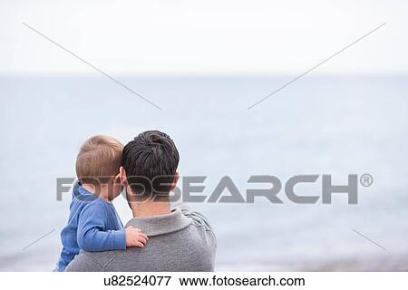 "Father and young son looking at sea view, rear view" View Large Photo Image Stock Photo - "Father and young son looking at sea view, rear view". Fotosearch