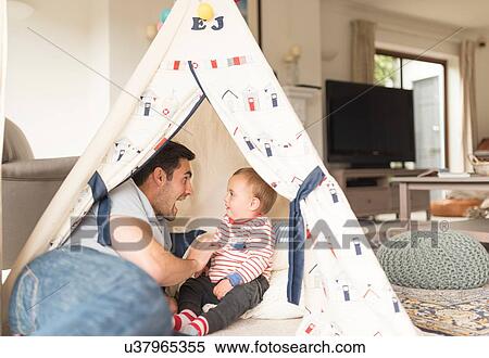 "Father and young son sitting in play tent indoors, laughing together" View Large Photo Image Stock Photography - "Father and young son sitting in play tent indoors, laughing together". Fotosearch