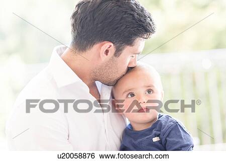 Stock Photograph - Father kissing young son on head. Fotosearch