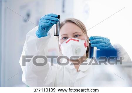 Stock Photo - Female scientist holding plasma enhanced dispersion samples of graphene in graphene processing factory. Fotosearch