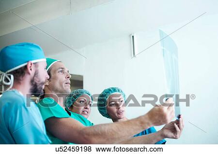 Stock Photo - Four male and female orthopedic surgeons examining x-ray image. Fotosearch