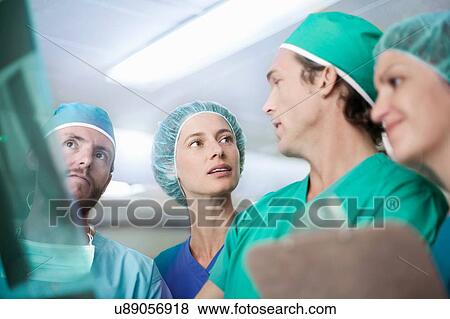 Stock Photo - Four male and female orthopedic surgeons discussing x-ray image. Fotosearch
