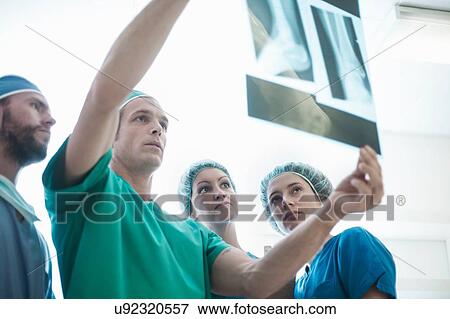 Four male and female orthopedic surgeons holding up x-ray image View Large Photo Image Stock Photo - Four male and female orthopedic surgeons holding up x-ray image. Fotosearch