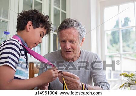 Picture - Grandfather and grandson looking at medals around grandson's neck. Fotosearch