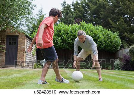 Grandfather and grandson playing with football in garden View Large Photo Image Stock Image - Grandfather and grandson playing with football in garden. Fotosearch