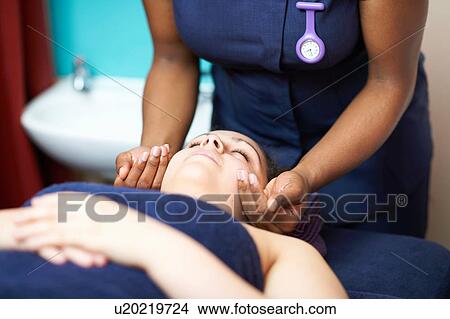 "Head and shoulders of young woman lying down having facial massage, eyes closed" View Large Photo Image Picture - "Head and shoulders of young woman lying down having facial massage, eyes closed". Fotosearch