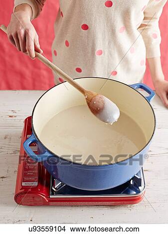 Picture - High angle view of mid adult womans mid section making gochuchang in a saucepan. Fotosearch