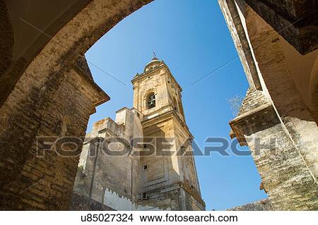 Picture - "Low angle arch view of tower of Medina Sidonia chuch, Andalucia, Spain". Fotosearch