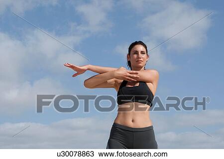 Low angle view of blue sky and mid adult woman exercising View Large Photo Image Stock Image - Low angle view of blue sky and mid adult woman exercising. Fotosearch