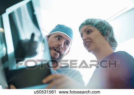 Male and female orthopedic surgeons pointing at x-ray image View Large Photo Image Stock Image - Male and female orthopedic surgeons pointing at x-ray image. Fotosearch