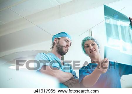 Male and female orthopedic surgeons reviewing x-ray image View Large Photo Image Stock Photography - Male and female orthopedic surgeons reviewing x-ray image. Fotosearch