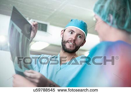 Stock Photography - Male and female orthopedic surgeons discussing x-ray image. Fotosearch