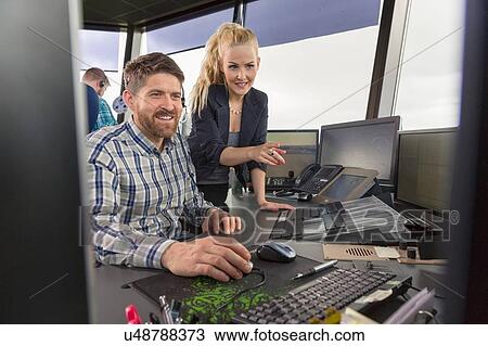 Stock Image - Man and woman working in air traffic control. Fotosearch