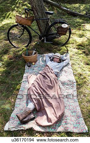 Mature female forager resting on blanket in forest View Large Photo Image Picture - Mature female forager resting on blanket in forest. Fotosearch
