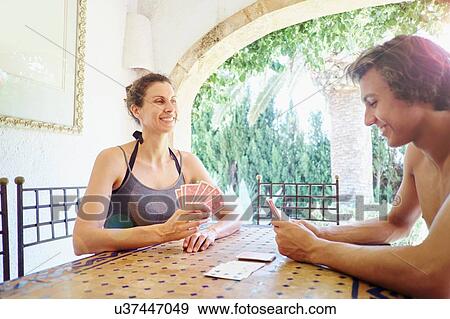 Mature woman and son playing cards at patio table View Large Photo Image Stock Photo - Mature woman and son playing cards at patio table. Fotosearch