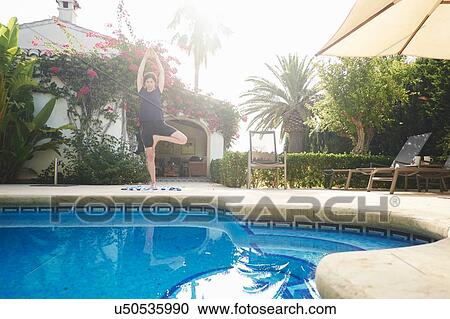 Mature woman in yoga pose at holiday apartment poolside View Large Photo Image Stock Image - Mature woman in yoga pose at holiday apartment poolside. Fotosearch