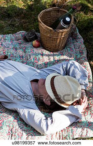Stock Photo - Mature woman resting on blanket on forest floor. Fotosearch
