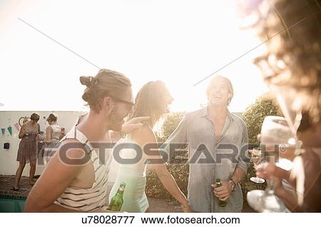 Men and young women drinking and chatting at poolside party View Large Photo Image Stock Photo - Men and young women drinking and chatting at poolside party. Fotosearch