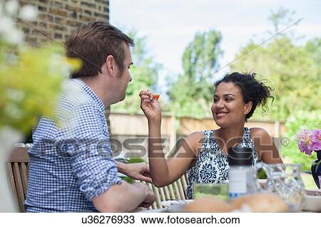 Mid adult couple eating meal outdoors View Large Photo Image Stock Image - Mid adult couple eating meal outdoors. Fotosearch