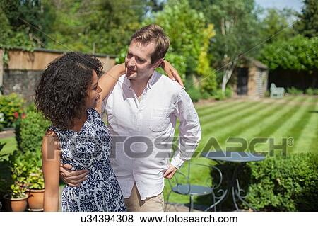 Stock Photo - "Mid adult couple embracing, outdoors". Fotosearch
