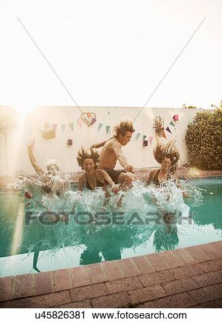 Mid adult man and three young women splashing into swimming pool at poolside party View Large Photo Image Stock Image - Mid adult man and three young women splashing into swimming pool at poolside party. Fotosearch