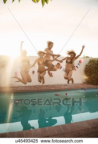 Mid adult man and three young women jumping into swimming pool at party View Large Photo Image Stock Photography - Mid adult man and three young women jumping into swimming pool at party. Fotosearch