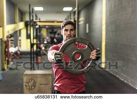 Mid adult man working out at gym View Large Photo Image Stock Image - Mid adult man working out at gym. Fotosearch