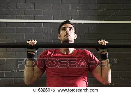 Stock Photography - Mid adult man working out at gym. Fotosearch