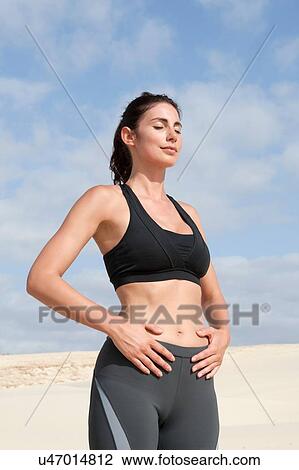 Mid adult woman exercising with eyes closed and hands on stomach at beach View Large Photo Image Stock Image - Mid adult woman exercising with eyes closed and hands on stomach at beach. Fotosearch
