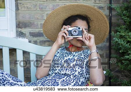 "Mid adult woman, outdoors, taking photograph with vintage camera" View Large Photo Image Stock Image - "Mid adult woman, outdoors, taking photograph with vintage camera". Fotosearch